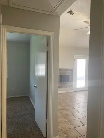 a view of a hallway with wooden floor and a bathroom