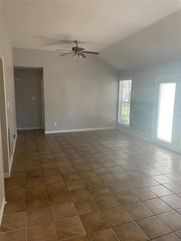a view of a livingroom with a chandelier fan and windows