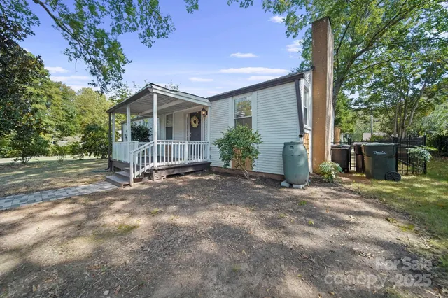 a view of a house with a yard and large tree