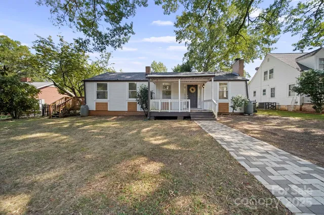 a front view of a house with a yard and trees