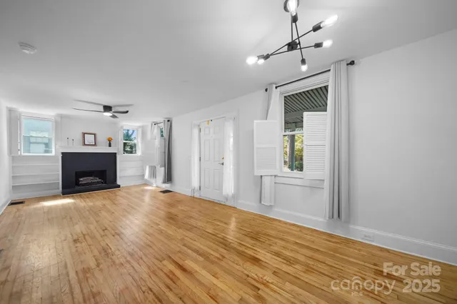 a view of empty room with wooden floor and fireplace