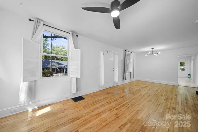 a view of empty room with wooden floor and windows