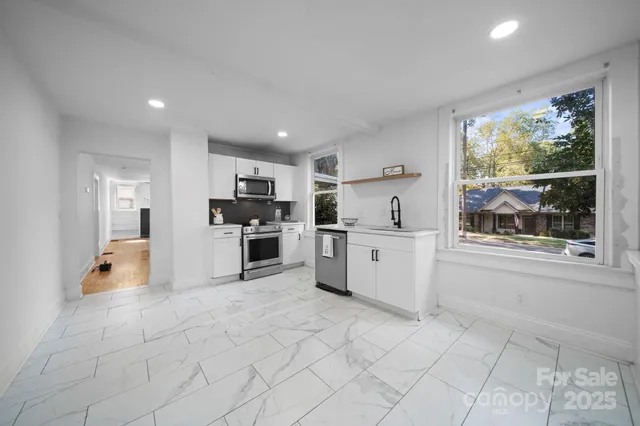 a kitchen with stainless steel appliances a refrigerator sink and cabinets