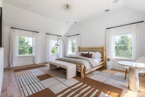 a bedroom with a bed lamp on table and a window