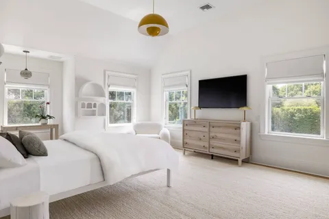 a bedroom with a bed and flat screen tv