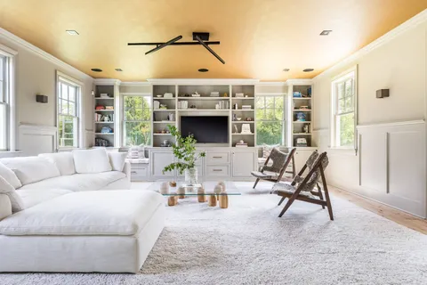 a living room with furniture a fireplace and a floor to ceiling window