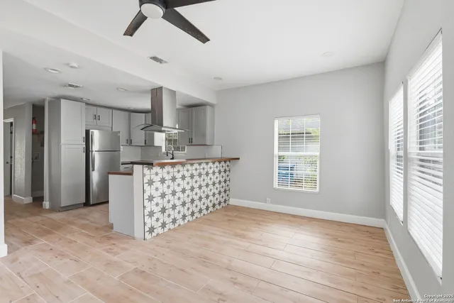 a kitchen with stainless steel appliances kitchen island granite countertop a refrigerator and a sink