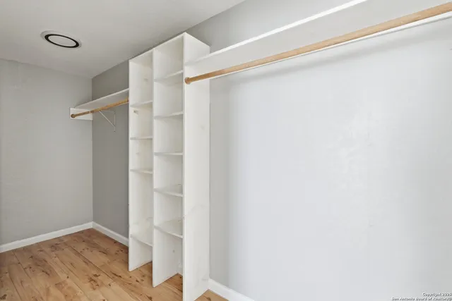 a view of walk in closet with empty racks