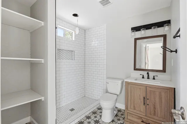 a bathroom with a sink a toilet and shower