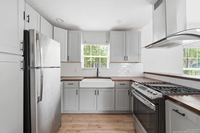 a kitchen with stainless steel appliances a refrigerator sink and stove
