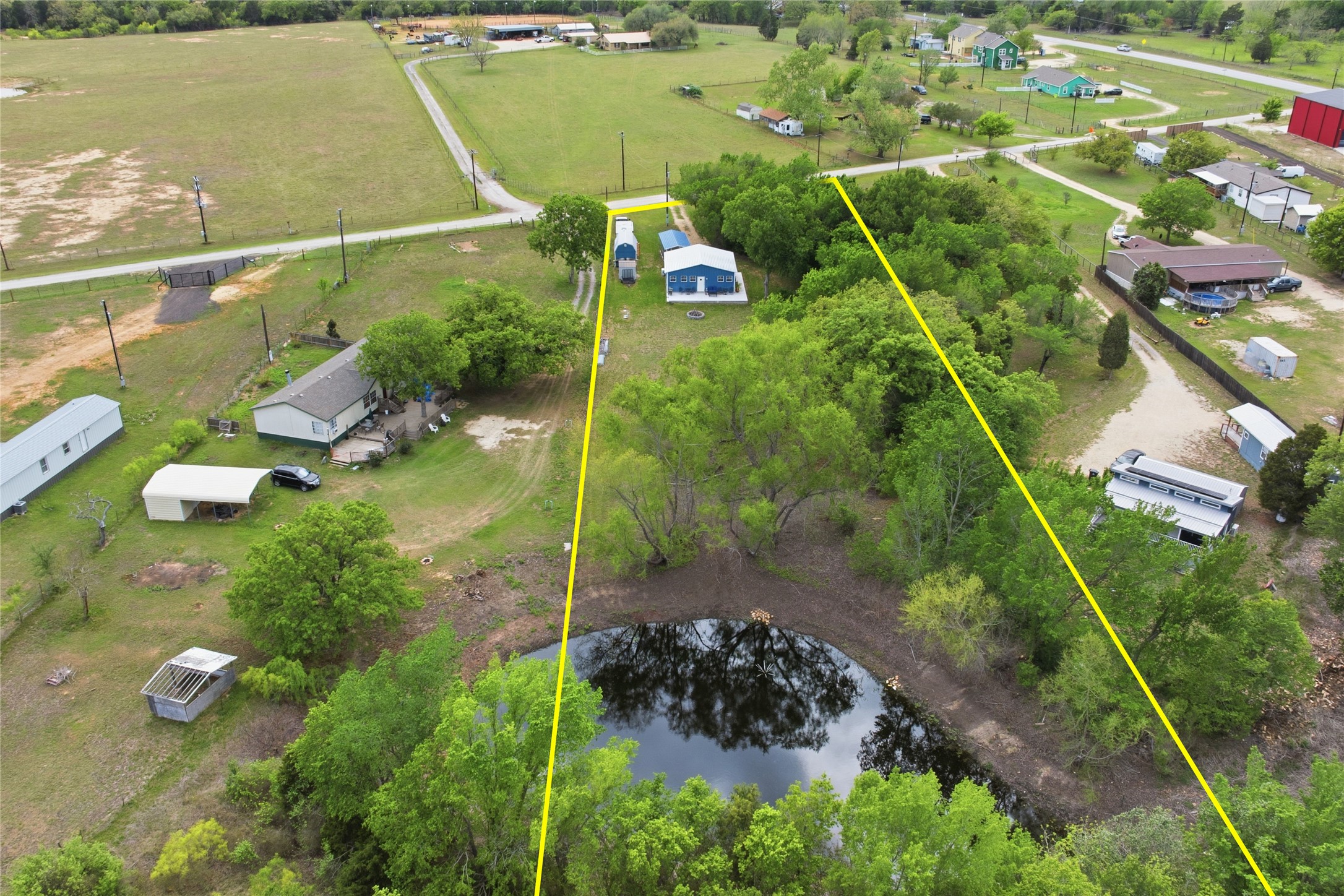 224 Old Coach Lane Elgin, TX 78621 - Photo 18 of 25 Aerial view of property and surrounding area featuring property parcel outlined and a nearby body of water