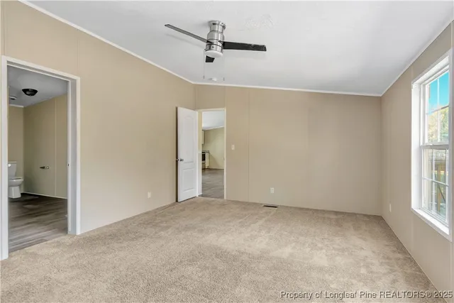 an empty room with windows and a ceiling fan