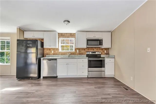 a kitchen with granite countertop a refrigerator stove and oven