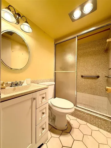 a bathroom with a sink mirror vanity and toilet