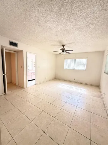 a view of a livingroom with an empty space and a window