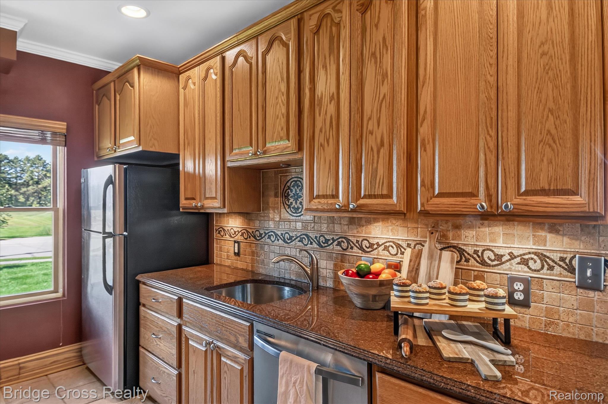285 East Long Lake Road Troy, MI 48085 - Photo 16 of 49 Wood-finish cabinetry, stone countertops, and a tiled backsplash with decorative accents