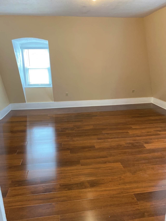 12 Baldwin Street, Unit 1 Newton, MA 02458 - Photo 4 of 7 a view of empty room with wooden floor and fan