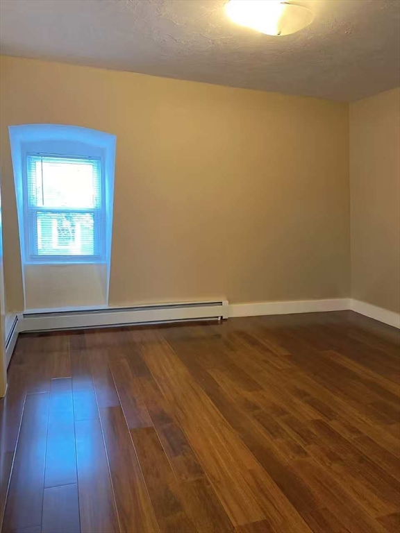 12 Baldwin Street, Unit 1 Newton, MA 02458 - Photo 5 of 7 a view of an empty room with wooden floor and a window