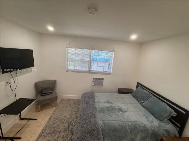 a bedroom with a bed and a flat screen tv