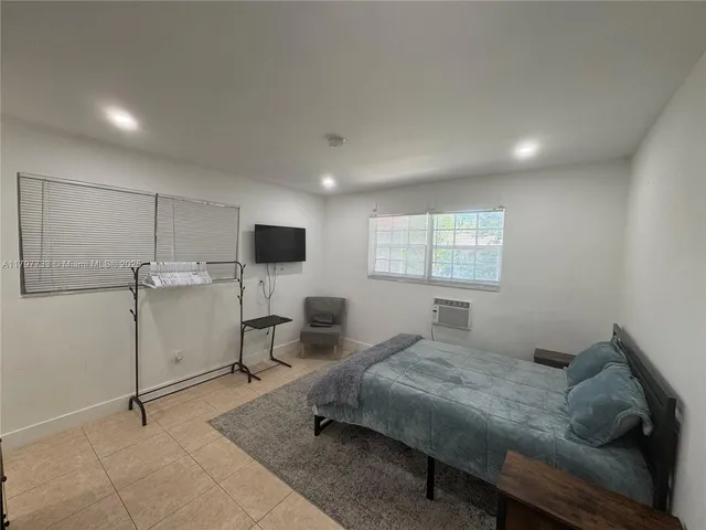 a bedroom with a bed and flat screen tv