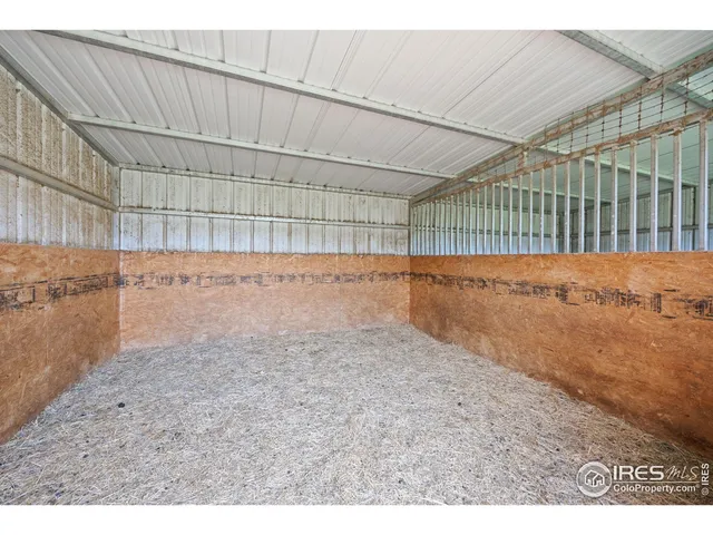 a view of a house with a large window and wooden fence