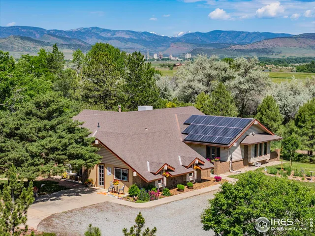 an aerial view of residential houses with outdoor space and trees