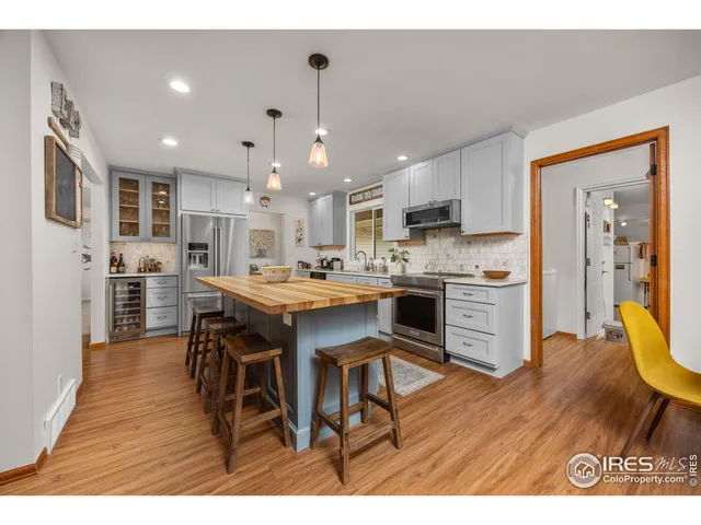 a kitchen with kitchen island granite countertop a sink cabinets and wooden floor