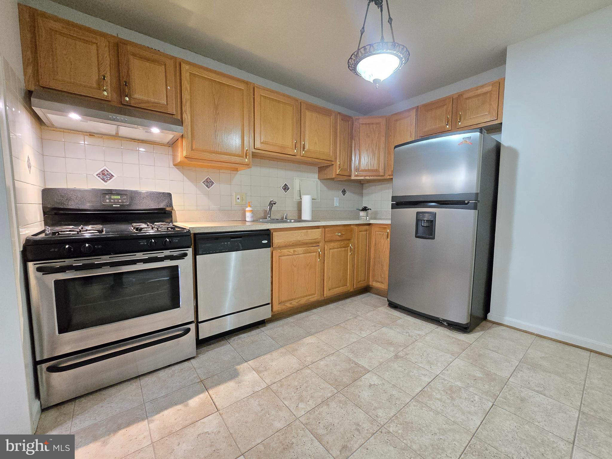 1836 Metzerott Road, Unit 1524 Hyattsville, MD 20783 - Photo 13 of 22 a kitchen with stainless steel appliances granite countertop a stove a refrigerator a sink a microwave and cabinets