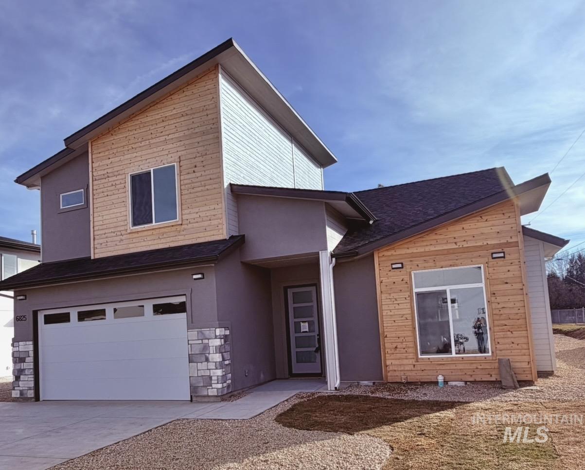 Modern home with a garage, stucco siding, and concrete driveway