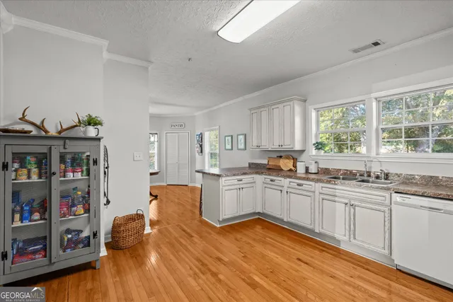 a kitchen with stainless steel appliances granite countertop wooden floors and sink