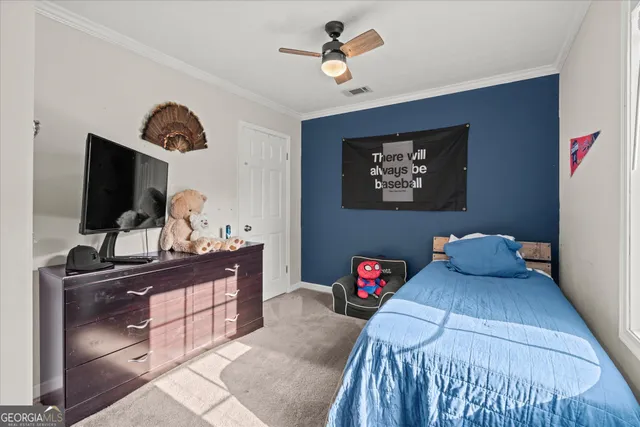 a bedroom with a bed and flat tv screen on the dresser