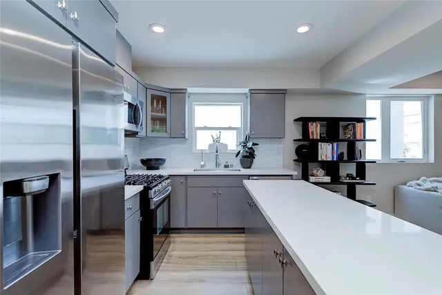 a view of a hallway view with a potted plant on a counter top space and wooden floor