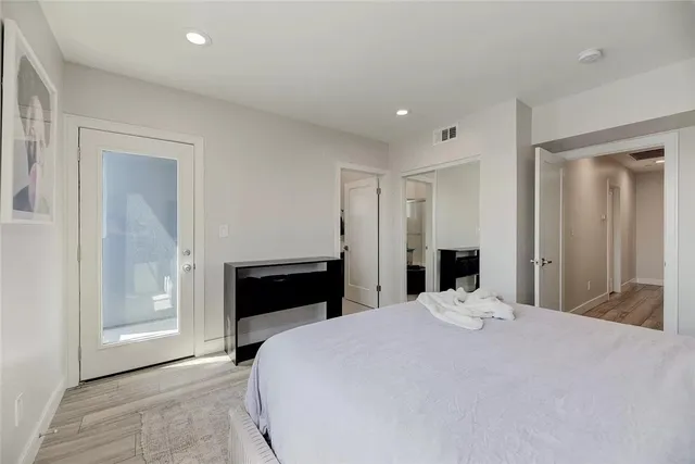 a bedroom with a bed and a flat tv screen on wall