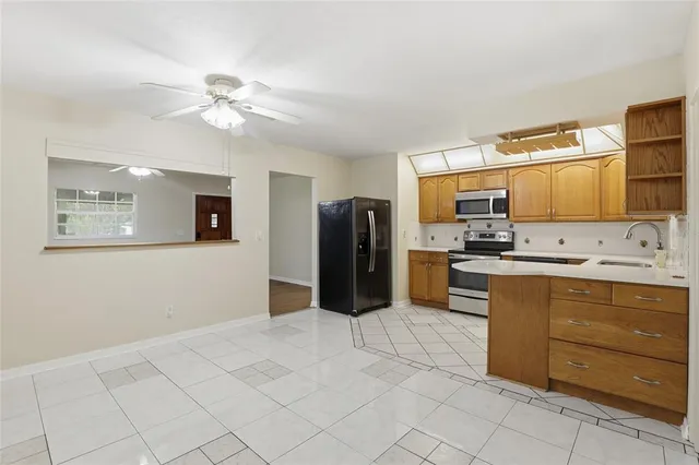 a kitchen with stainless steel appliances kitchen island granite countertop a refrigerator and cabinets