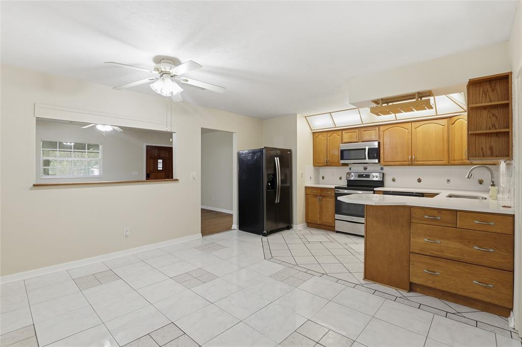 24214 Northwest 52nd Terrace Alachua, FL 32615 - Photo 14 of 22 a kitchen with stainless steel appliances kitchen island granite countertop a refrigerator and cabinets