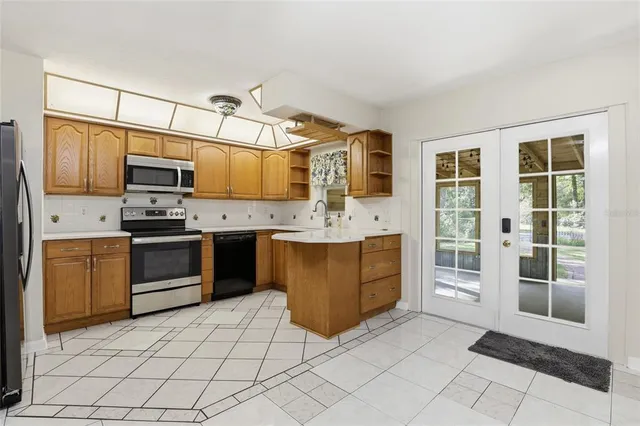a kitchen with stainless steel appliances a stove sink and microwave