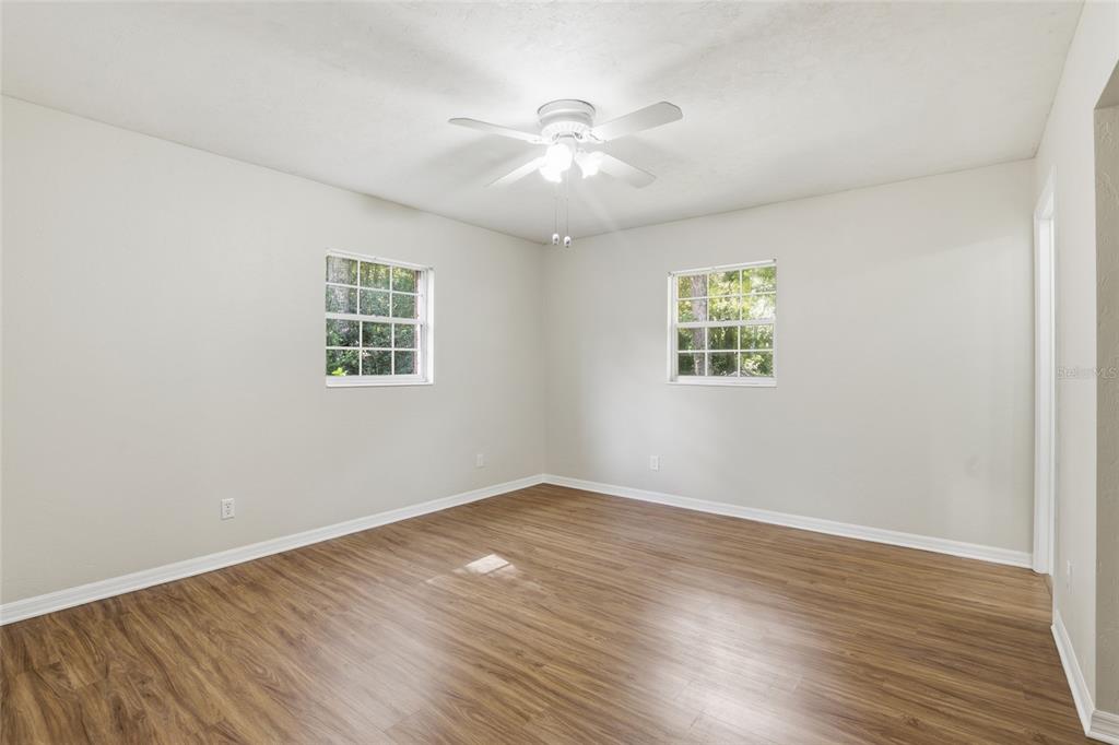 24214 Northwest 52nd Terrace Alachua, FL 32615 - Photo 18 of 22 an empty room with wooden floor and windows