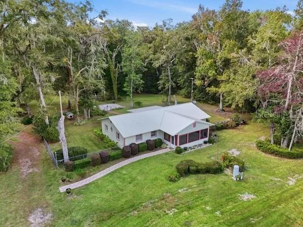 an aerial view of a house with backyard and pool