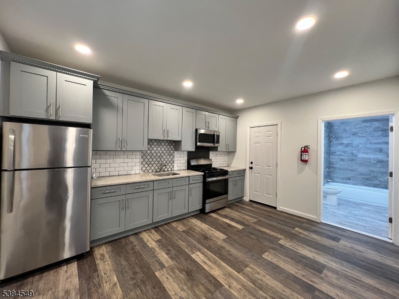 a kitchen with granite countertop a refrigerator and a sink