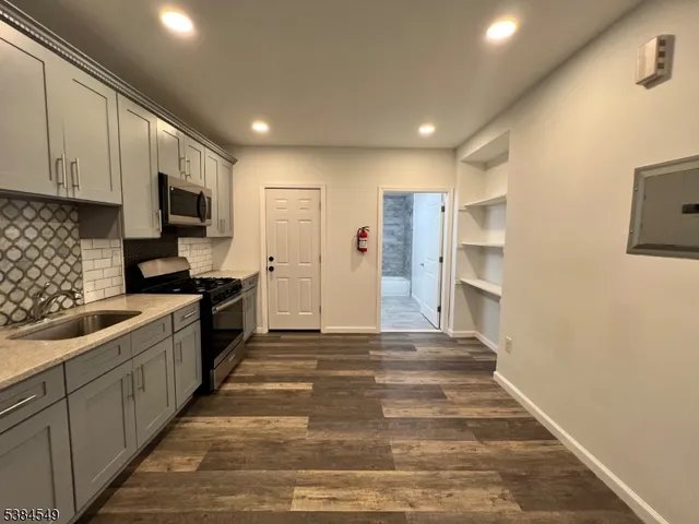 a large kitchen with stainless steel appliances granite countertop a sink and cabinets