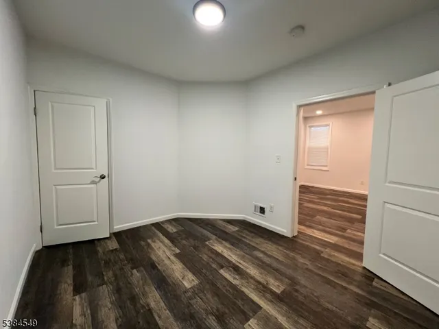 an empty room with wooden floor and closet