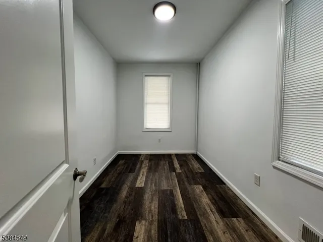 a view of a room with wooden floor and window