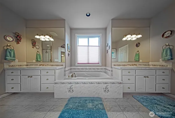 a bathroom with a granite countertop sink a large mirror and a bathtub