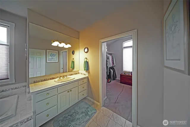 a bathroom with a granite countertop sink mirror and bathtub