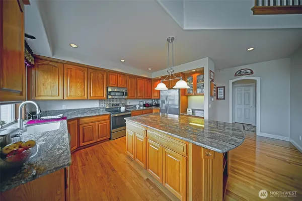 a kitchen with stainless steel appliances granite countertop a sink stove and refrigerator