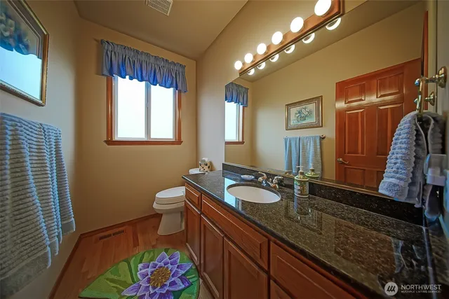 a spacious bathroom with a double vanity sink toilet and a mirror