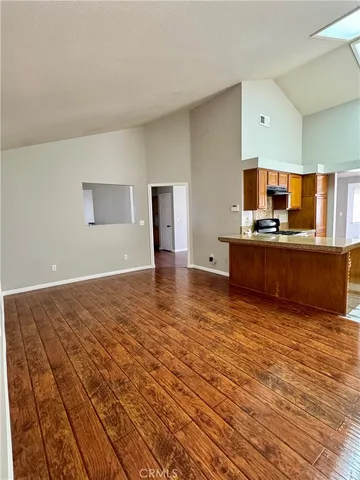a view of kitchen with kitchen island microwave and wooden floor