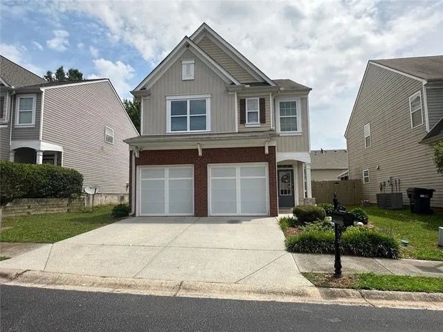 a front view of a house with a garden and garage