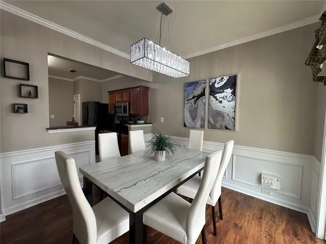 a view of a dining room with furniture a chandelier and wooden floor