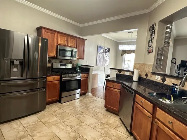 a kitchen with stainless steel appliances granite countertop a stove refrigerator and a sink